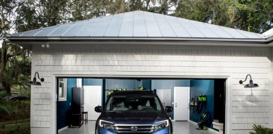 A photograph of a blue Ute parked in an open garage