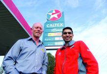 A photograph of two men standing in front of a Caltex sign