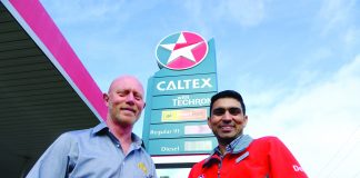 A photograph of two men standing in front of a Caltex sign