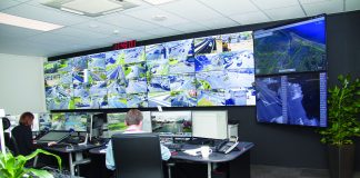 A picture of a man sitting in front of a bank of monitors at the Tauranga traffic control office