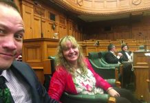 Photograph of a man and a woman sitting in the government chambers in Wellington
