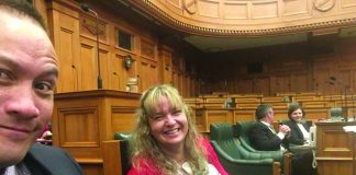 Photograph of a man and a woman sitting in the government chambers in Wellington