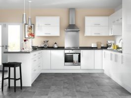a picture of a showroom kitchen with white cupboards and a steel rangehood