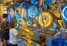Photograph of children in a museum looking at a display of brightly coloured gears