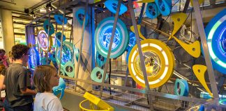 Photograph of children in a museum looking at a display of brightly coloured gears