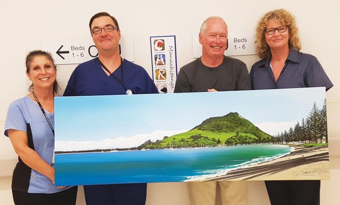 Artist Graham Baker with the painting he’s gifted to Tauranga Hospital’s Coronary Care Unit in recognition of the care he received after having a heart attack last year. Pictured left to right: Clinical Physiologist Michelle Bayles, Cardiology Clinical Nurse Manager Jason Money, Graham and CCU Clinical Nurse Manager Chris Southerwood.