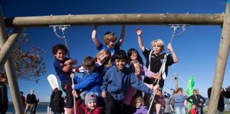 A group of children sitting on a tyre swing