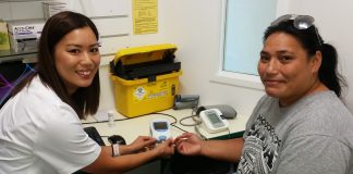 Pharmacist Rowena Fu (left) gives Lupe Poe (right) her INR test.