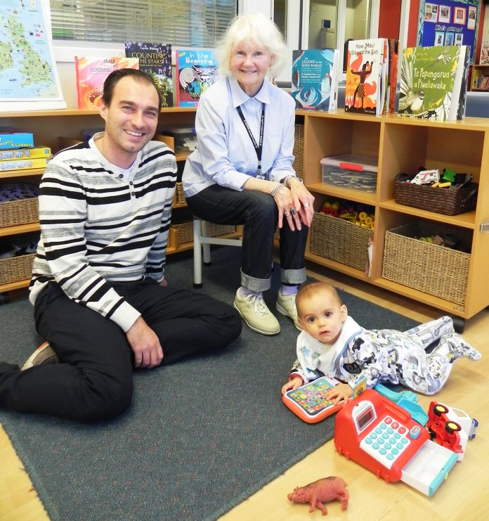 Michael Wenzel (left) with his 7-month-old son Lucas (right) and volunteer Doreen Birchfield (seated centre).