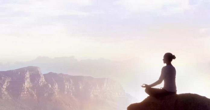 picture of a woman sitting on a rock meditating