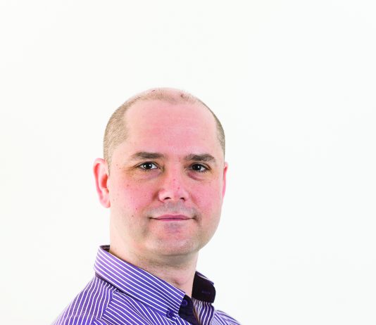 Picture of Rob Jackson UK Volunteer leader he is looking at the camera with his arms folderd he is wearing a purple business shirt