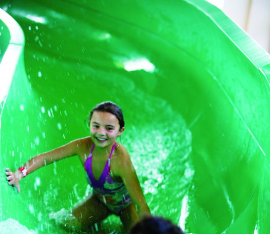 two children inside a green hydro slide