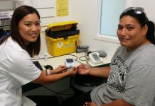 Pharmacist Rowena Fu (left) gives Lupe Poe (right) her INR test.