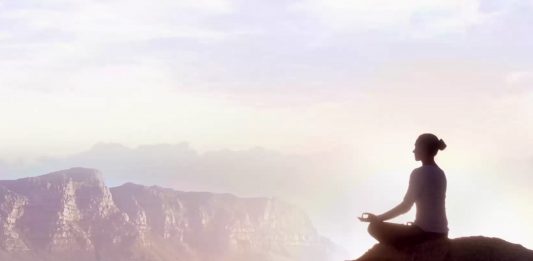 picture of a woman sitting on a rock meditating