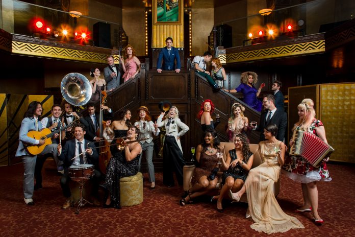 The cast of postmodern jukebox on a flight of stairs