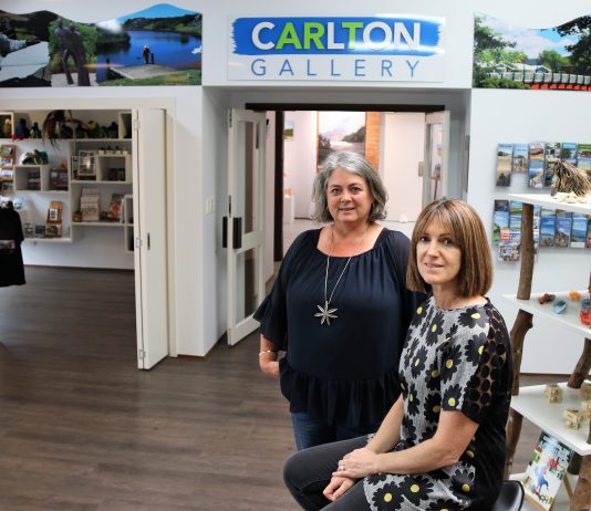 woman stands next to seated woman in Arts Junction Katikati